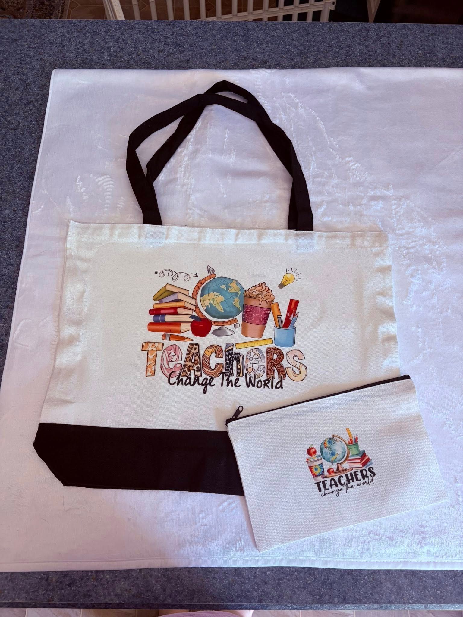 White tote bag and matching pouch with colorful logo, displayed on a light surface.