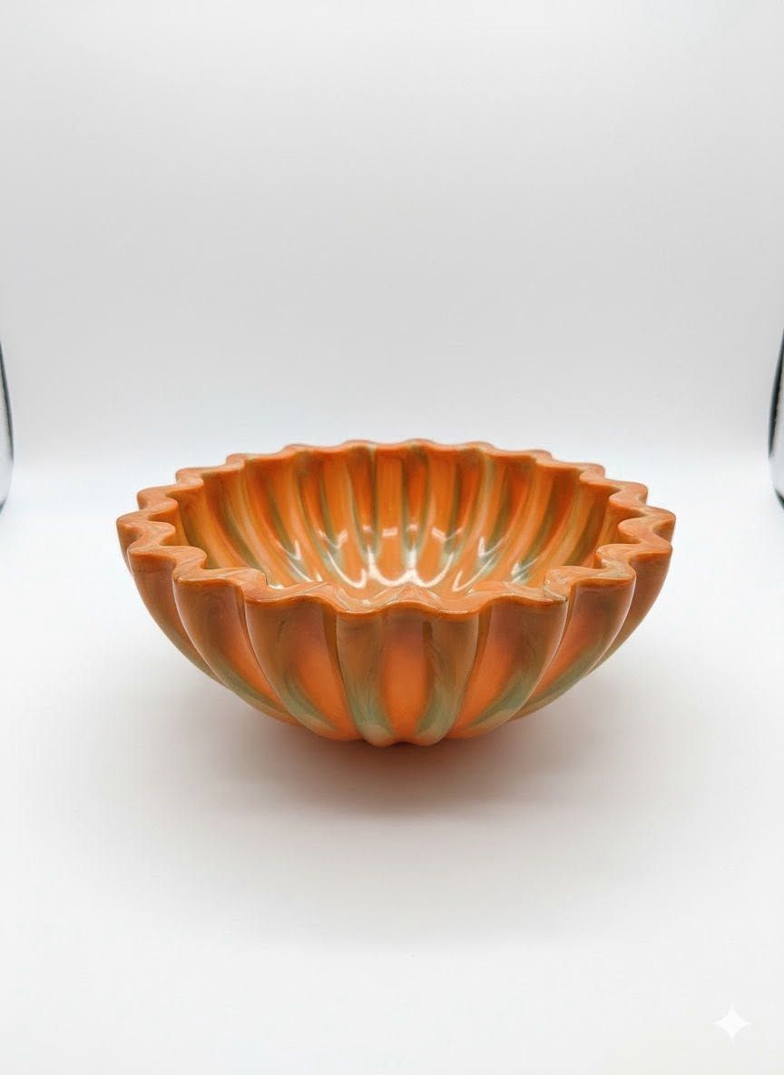 Orange and teal striped glass bowl on a white background