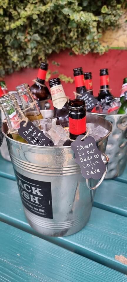 Bucket of bottled drinks on ice, with tags that read 