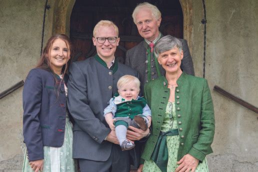 Eine Familie posiert mit einem Baby im Arm für ein Foto.