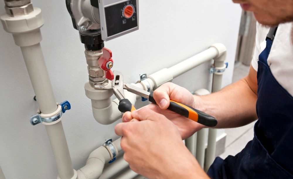 A Plumber Working on Pipes with A Wrench — Nuflow Wide Bay in Childers, QLD