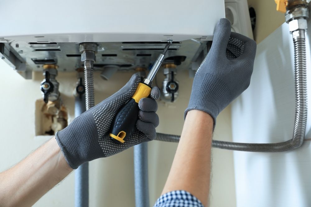 A Person Repairs a Appliance with A Screwdriver — Nuflow Wide Bay in Gin Gin, QLD