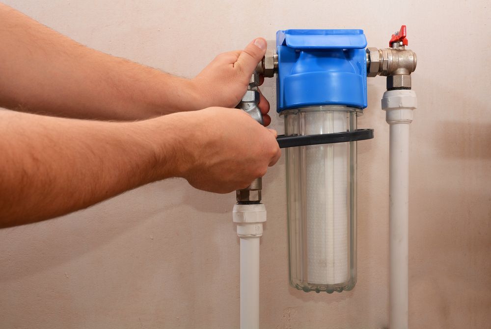 A Person Using a Tool to Unscrew a Water Filter — Nuflow Wide Bay in Woodgate, QLD