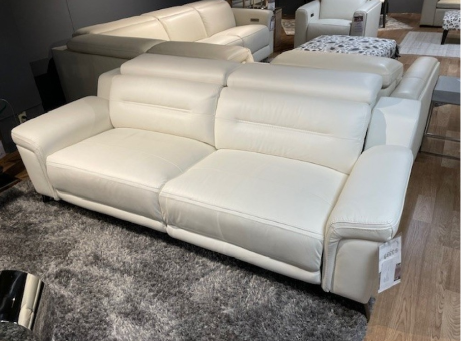 White leather sofa in a furniture store setting.