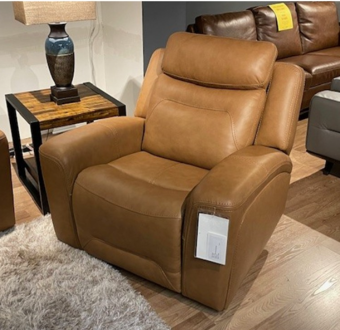 Tan leather recliner sofa with console, indoors on a rug.