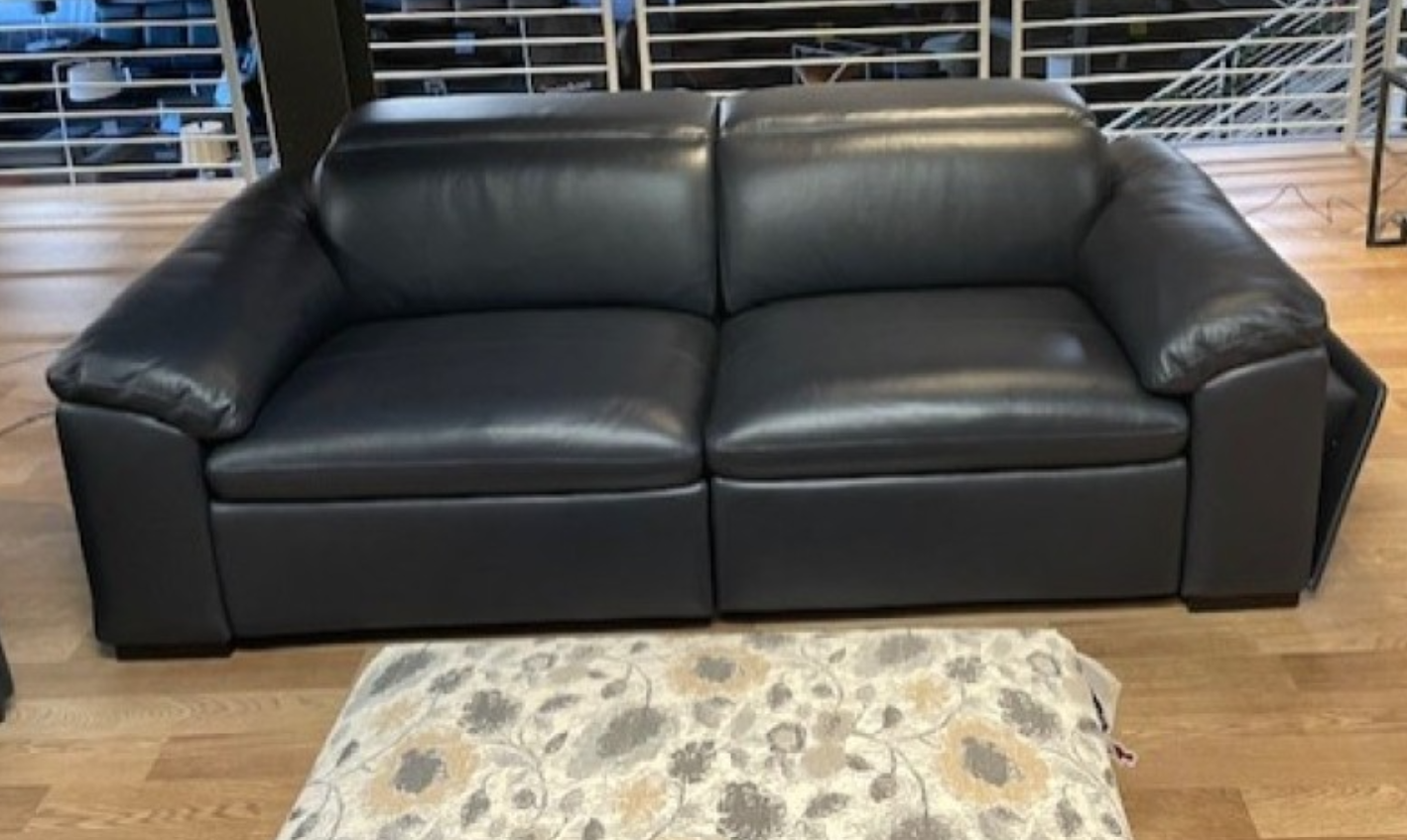 Black leather armchair with a cupholder and storage compartment. Interior setting.