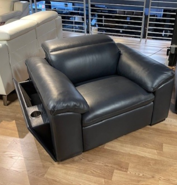 Black leather armchair with a cupholder and storage compartment. Interior setting.