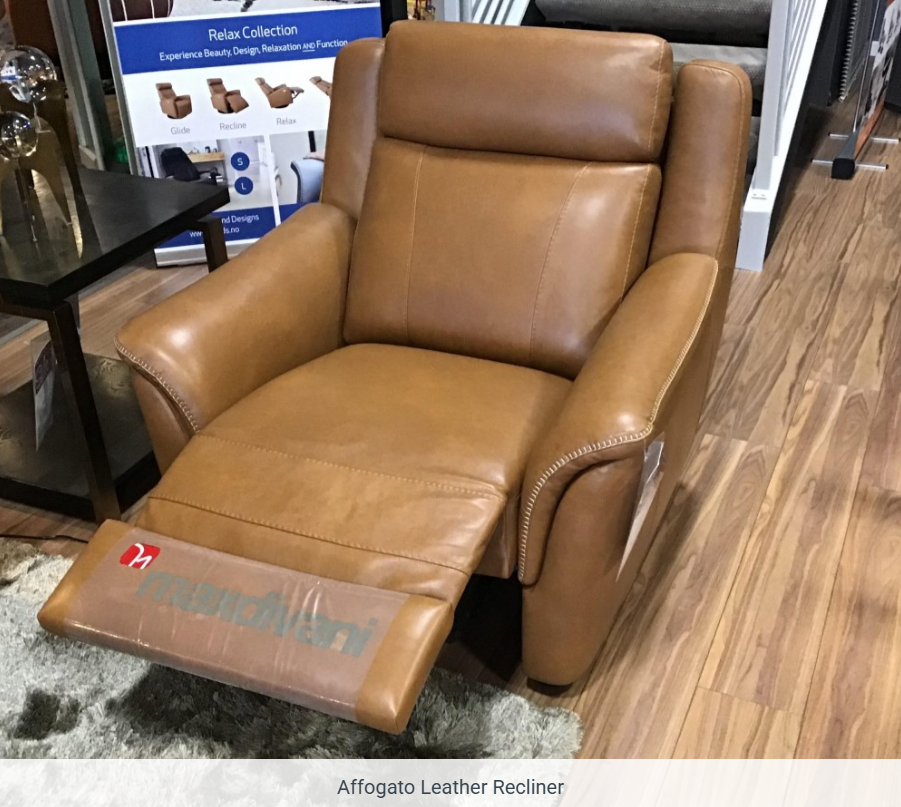 A tan leather recliner chair with visible stitching detail on the arms, featuring a protective plastic cover at the base.