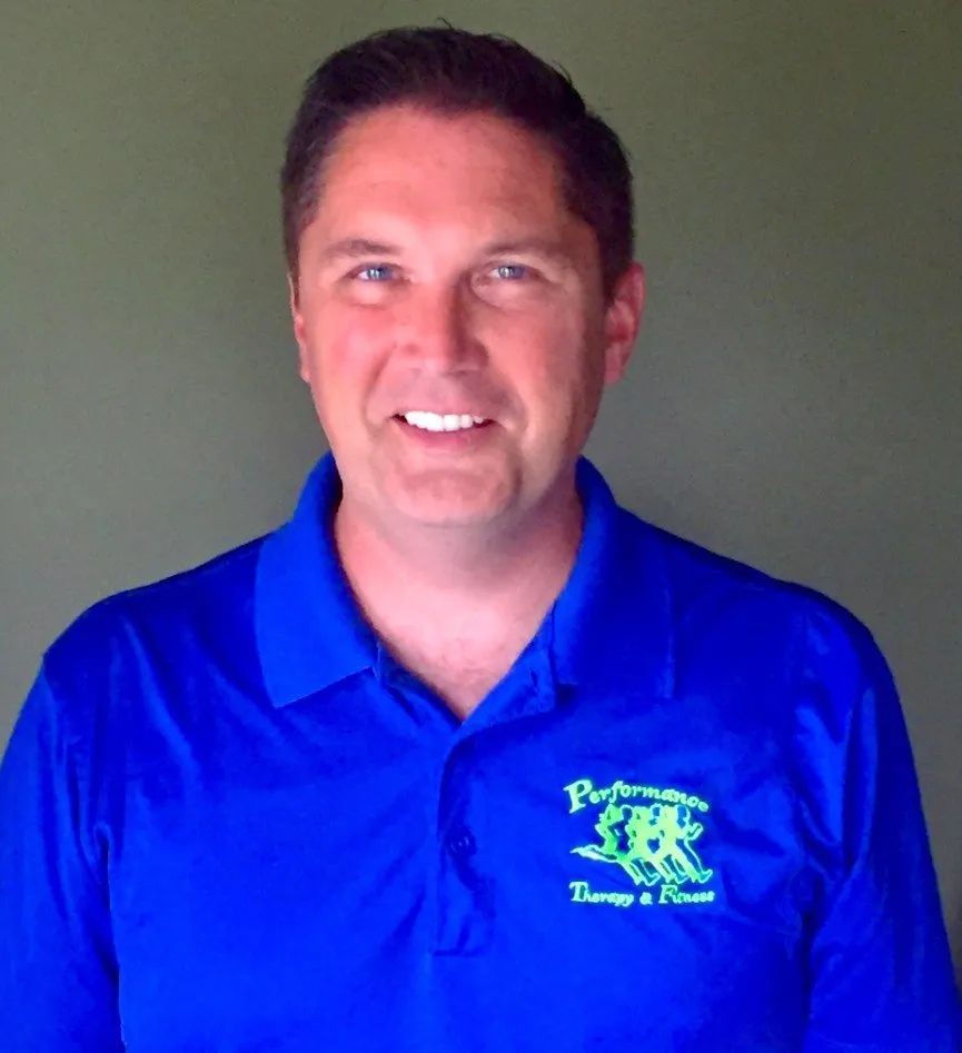 Man in blue polo shirt smiles, logo reads 