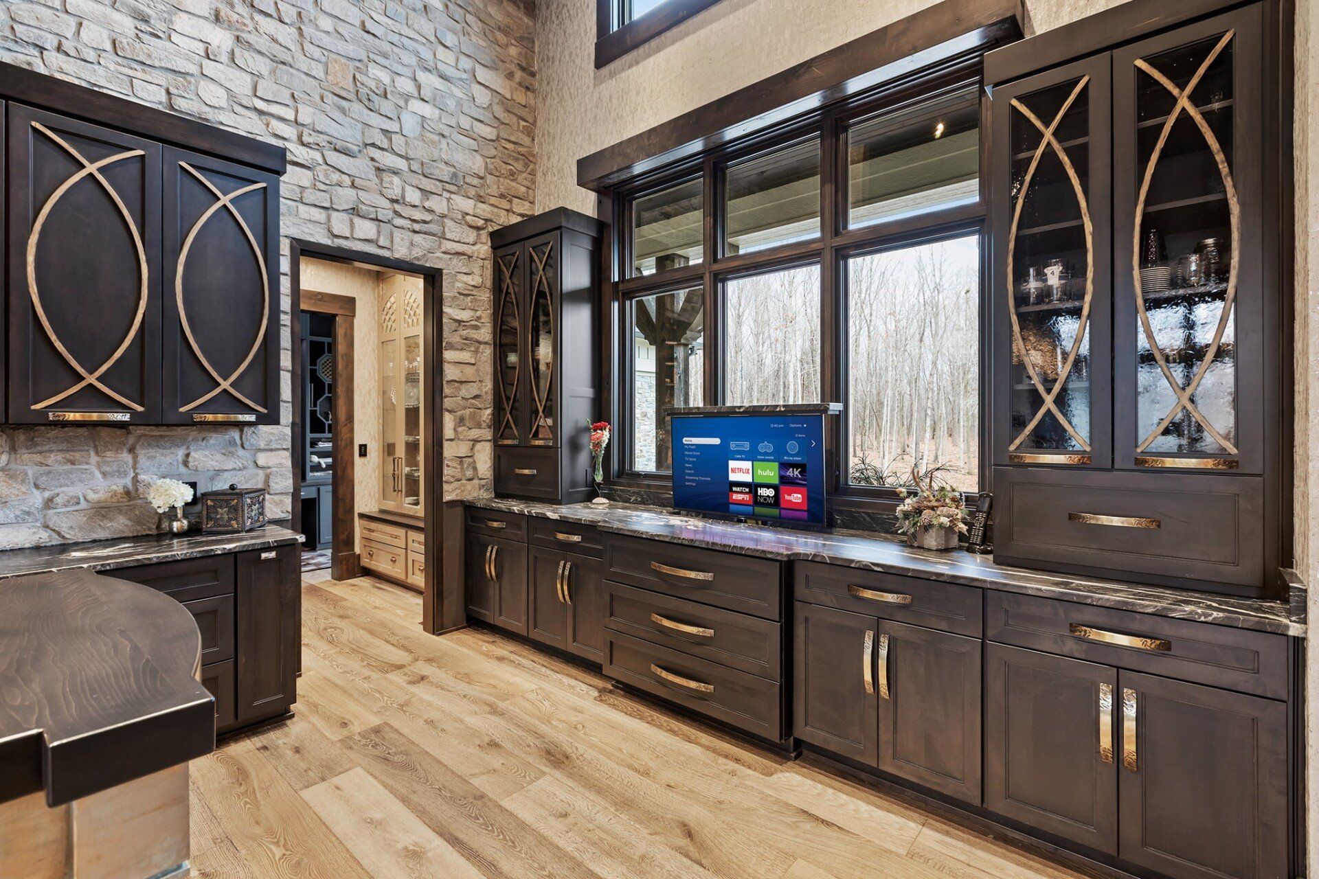 Modern and elegant kitchen interior. It features dark wood cabinets with intricate designs, cabinets by Unique WoodWorx LLC.