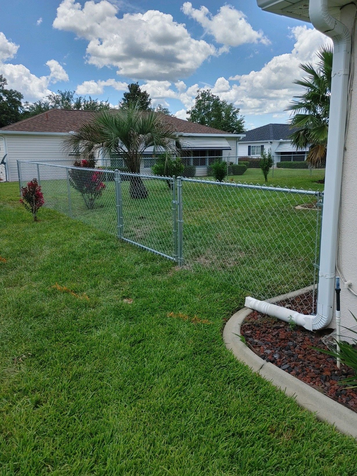 Residential chain link fence installation for a backyard to separate from neighbors yard