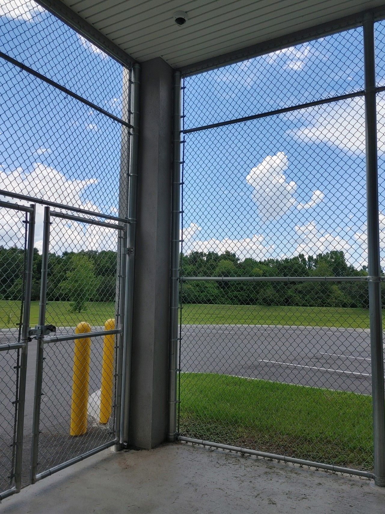 Corner view of a commercial chain link fence with doors that lock
