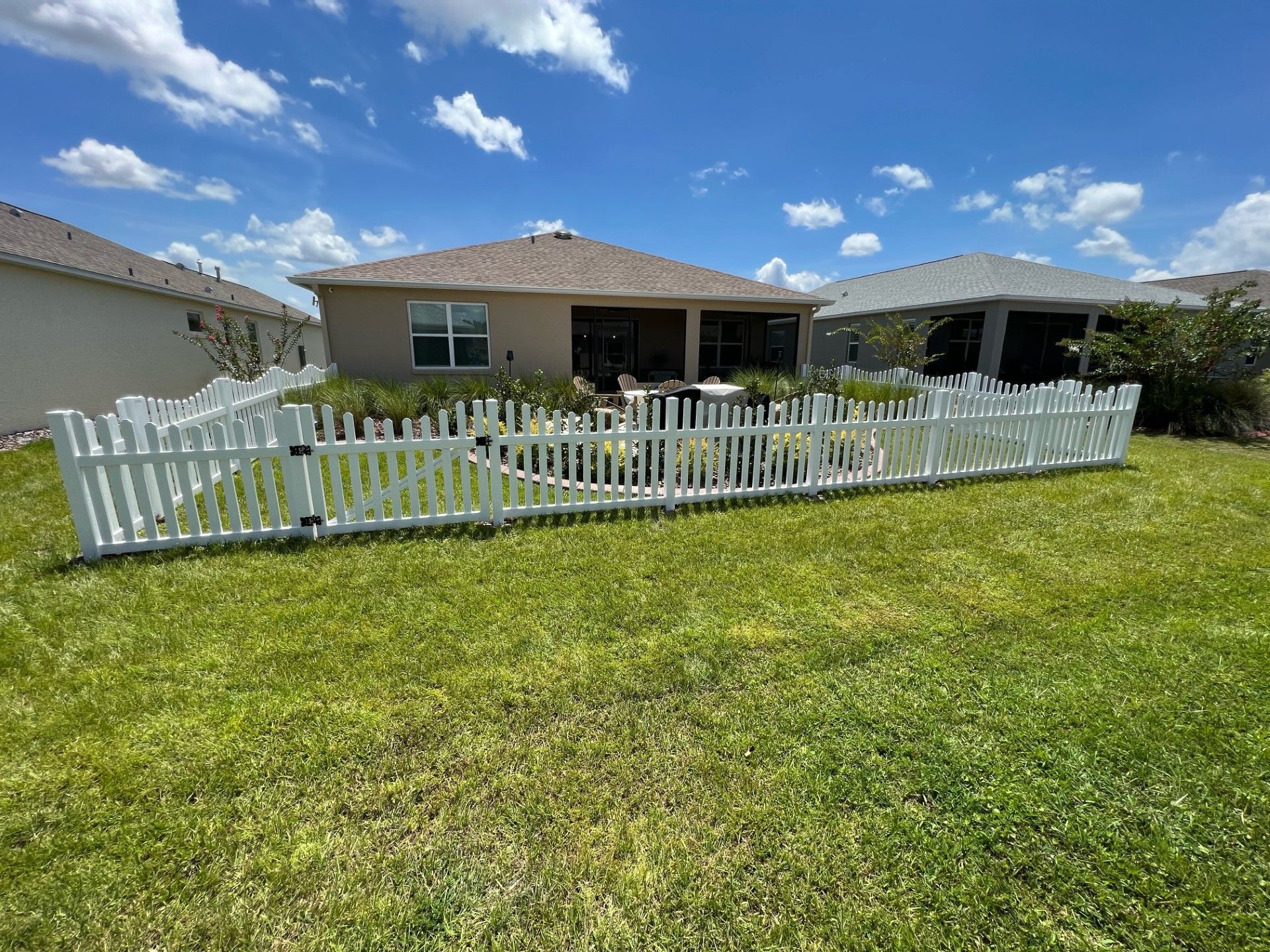 Front view of a short white vinyl residential fence installation