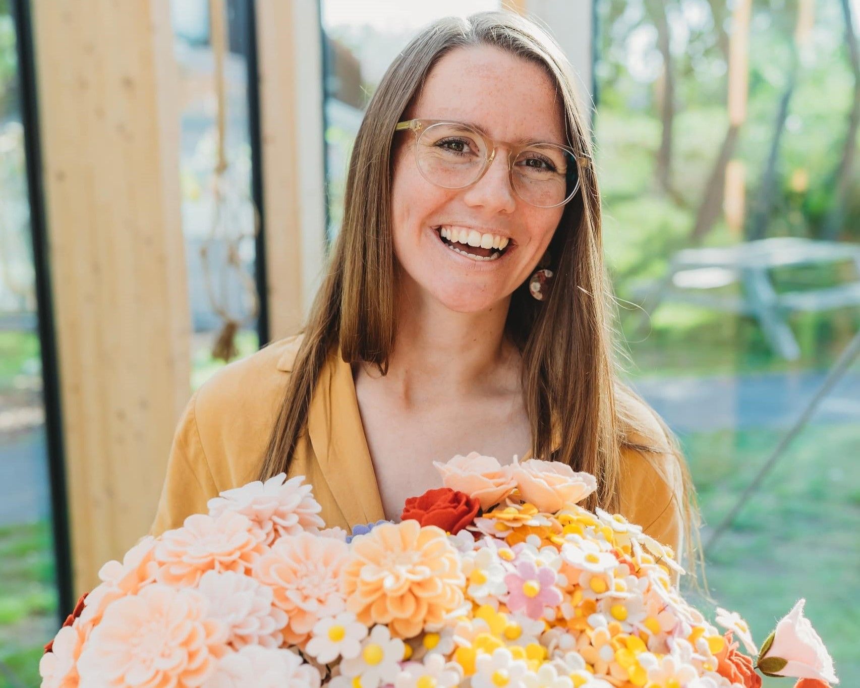 Patricia met vilten bloemen in haar handen
