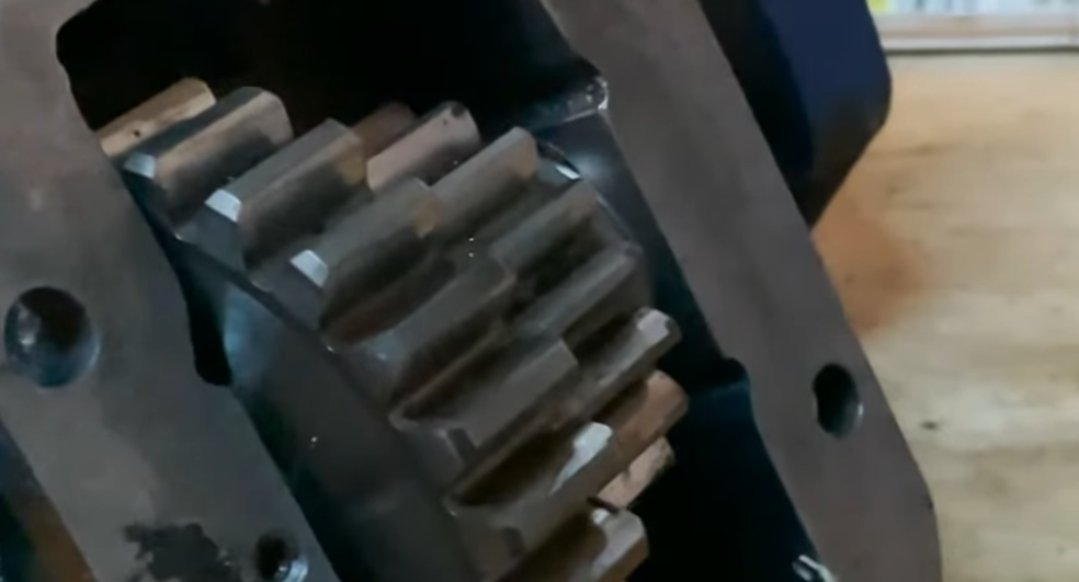 A close up of a gear on a machine on a wooden table.