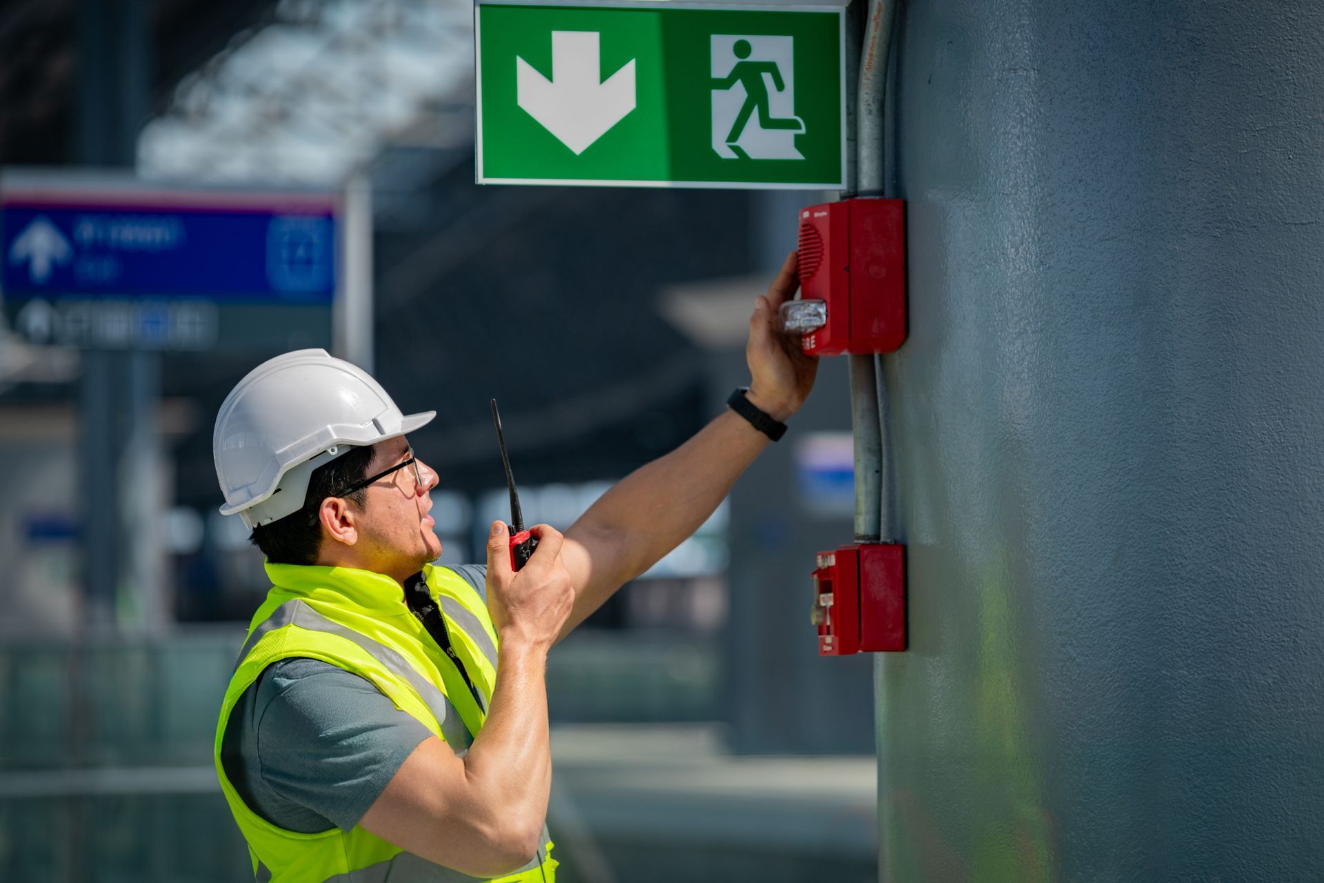 Man activating fire alarm pull station.
