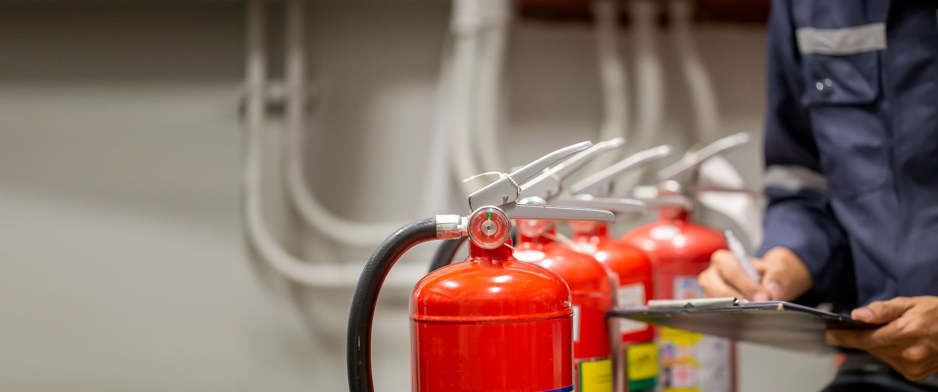 An engineer is performing fire safety services, checking and inspecting the fire extinguisher tanks. An engineer is performing fire safety services, checking and inspecting the fire extinguisher tanks.
