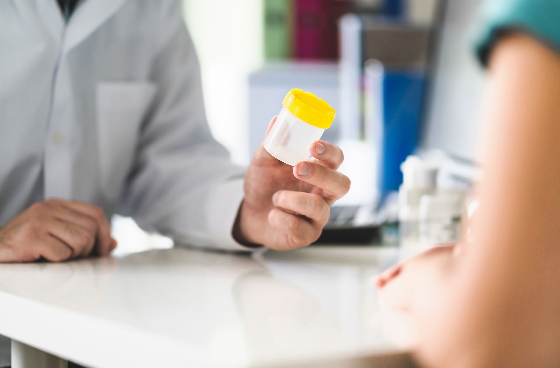 Physician giving pee container to a woman in clinic or hospital emergency room