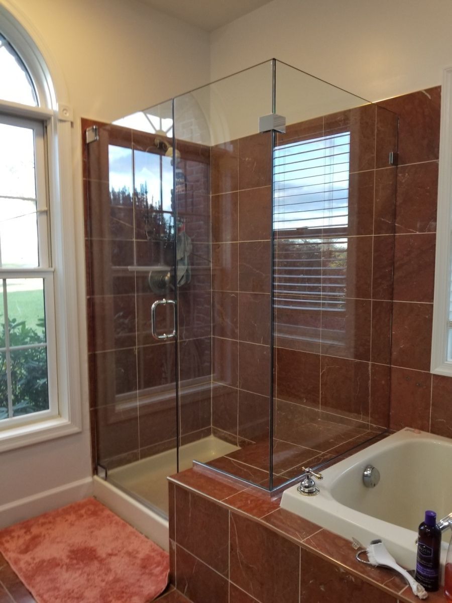 A bathroom with a tub a shower and a window