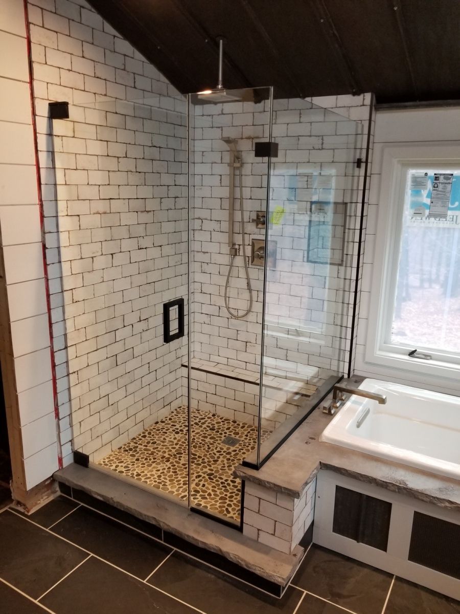 A bathroom with a walk in shower and a bathtub.