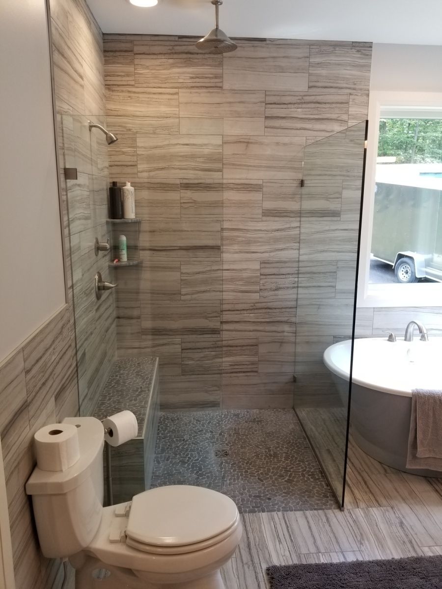 A bathroom with a toilet , bathtub and walk in shower.