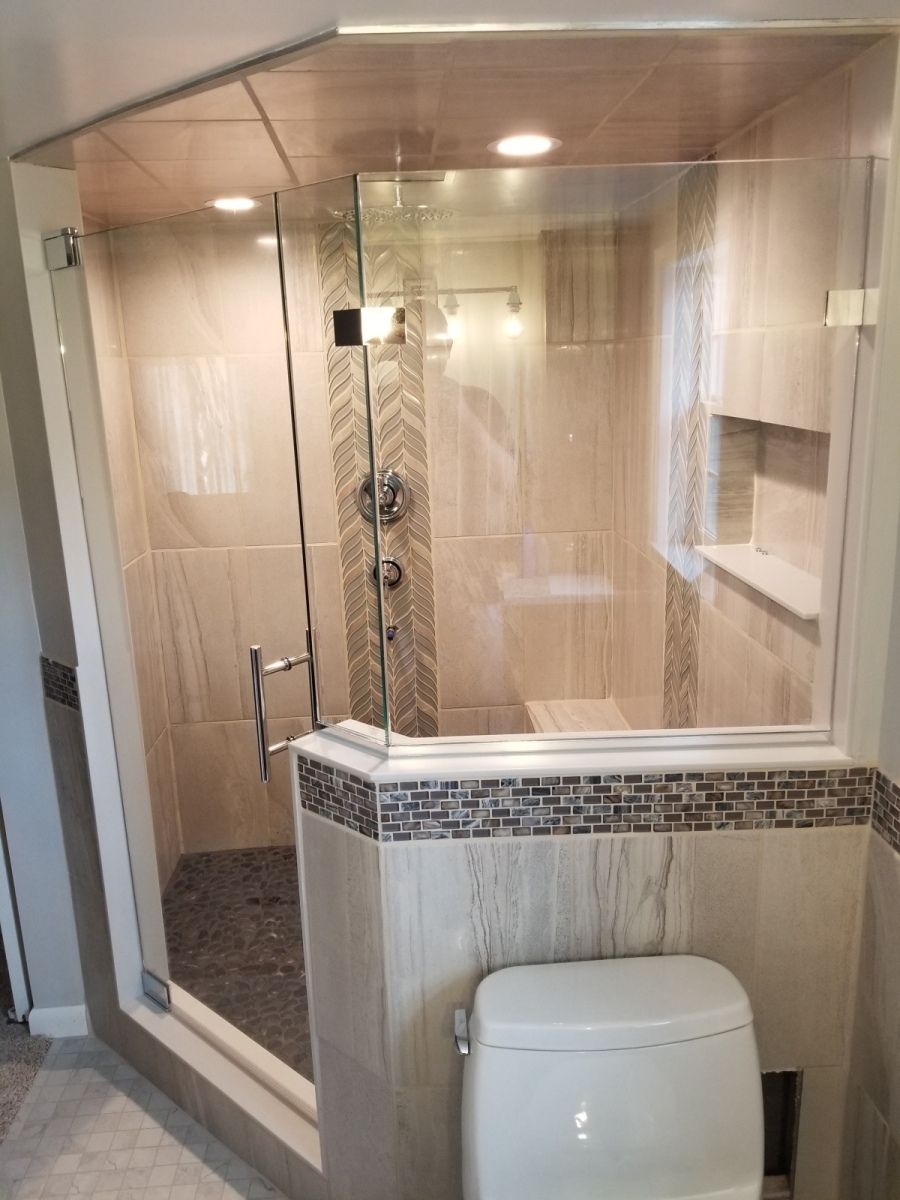 A bathroom with a toilet and a shower with a glass door.