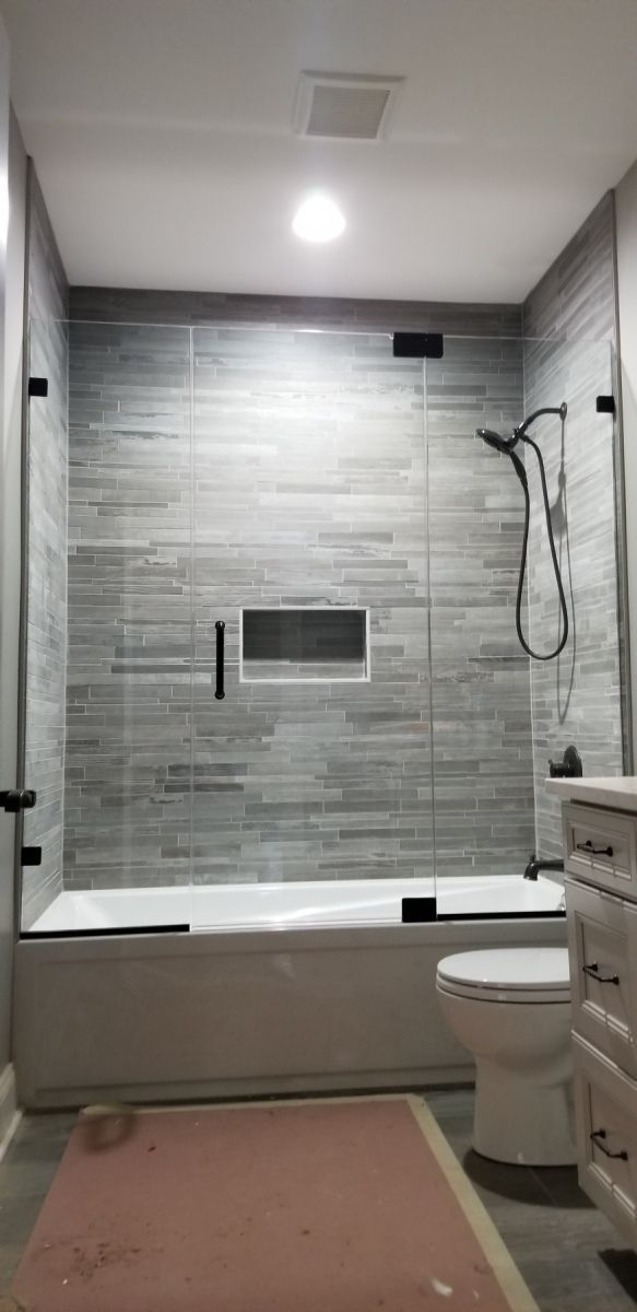 A bathroom with a bathtub , toilet and shower.