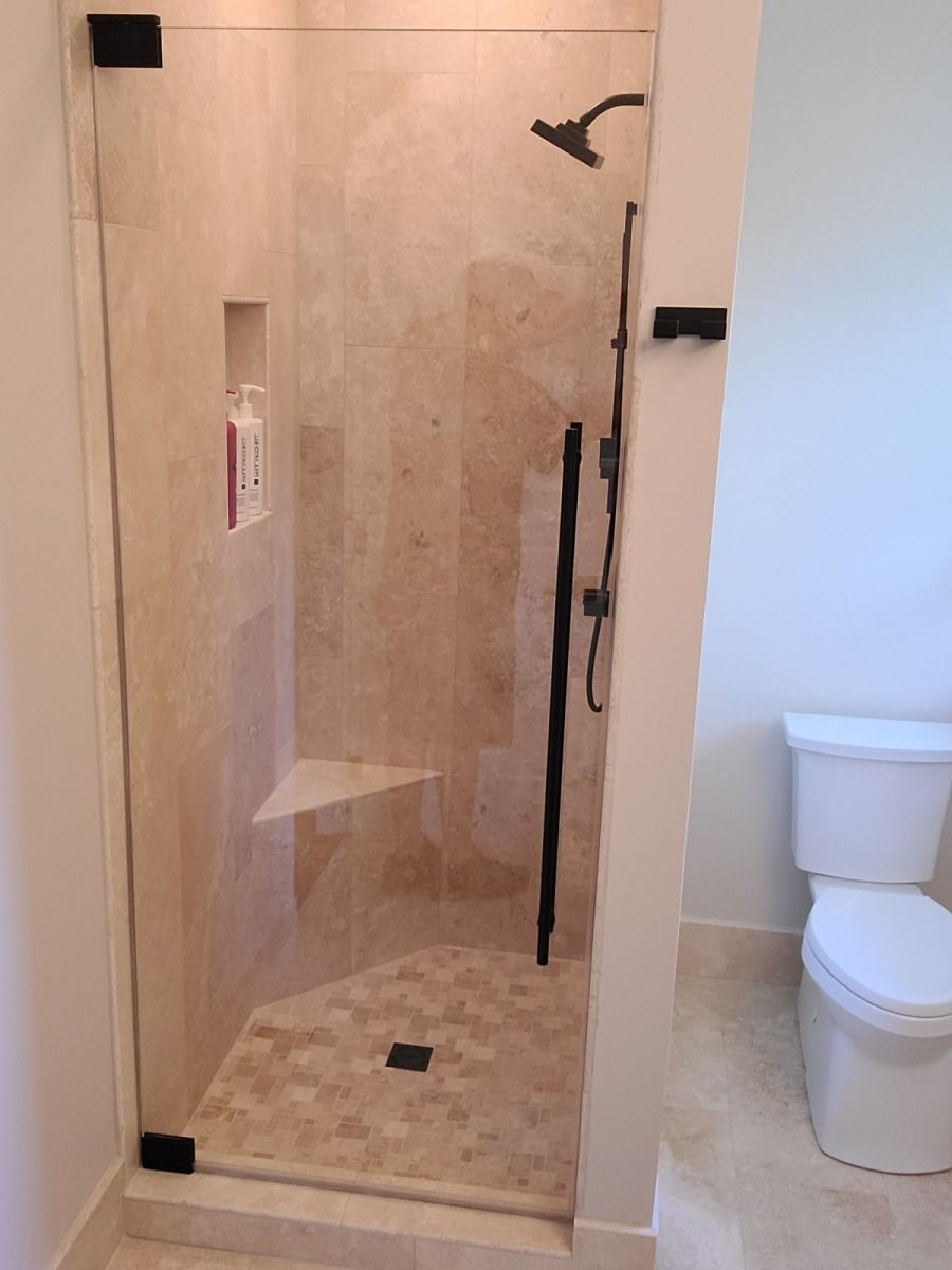 A bathroom with a walk in shower and a toilet.