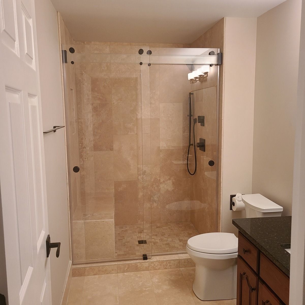 A bathroom with a toilet and a walk in shower