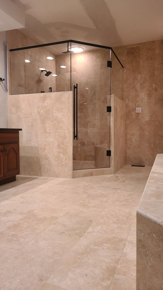 A bathroom with a walk in shower and a vanity.