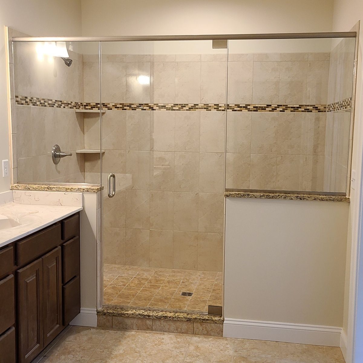 A bathroom with a walk in shower and a sink