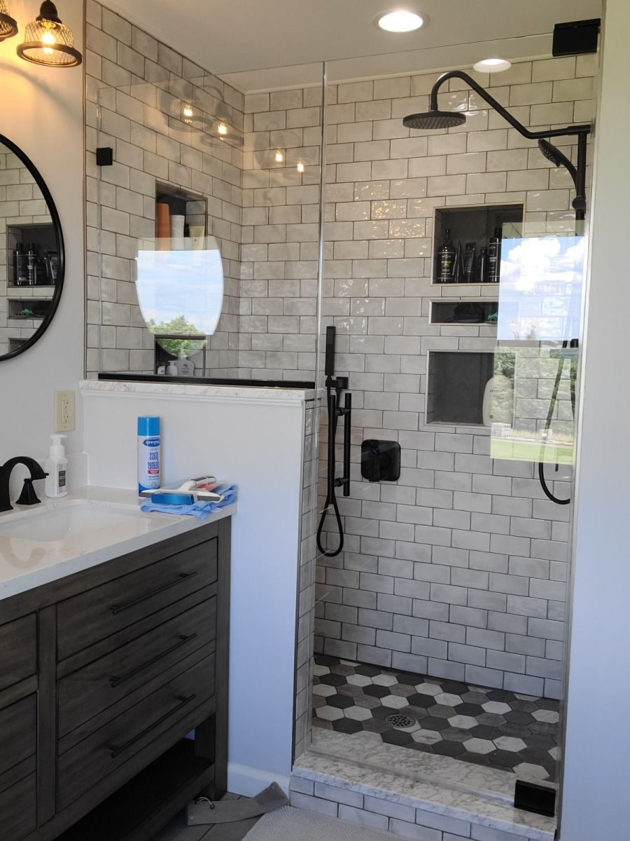 A bathroom with a walk in shower and a sink