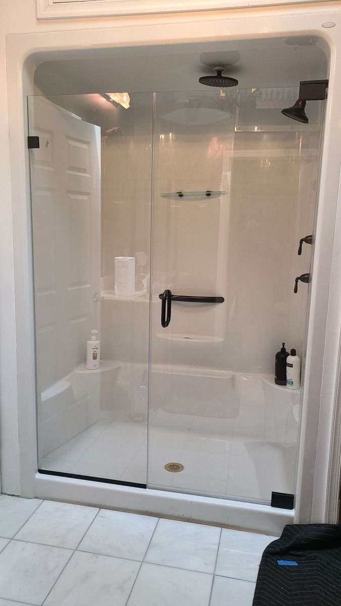 A bathroom with a bathtub and a shower with a glass door.
