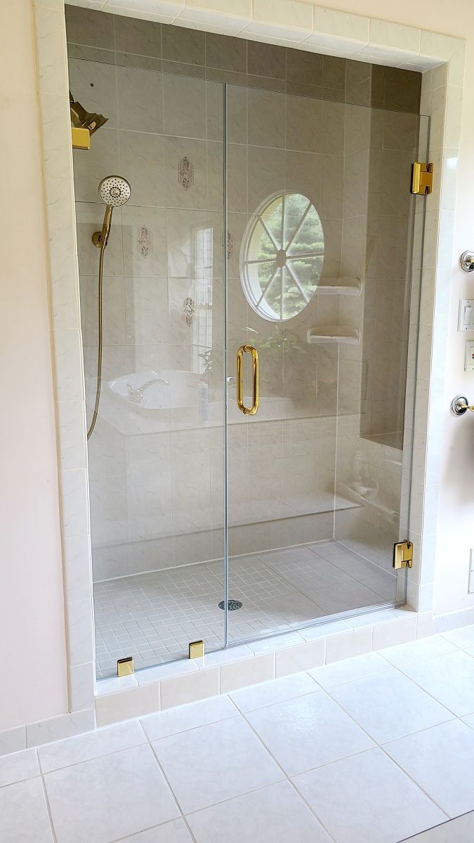 A bathroom with a glass shower door and a bathtub.