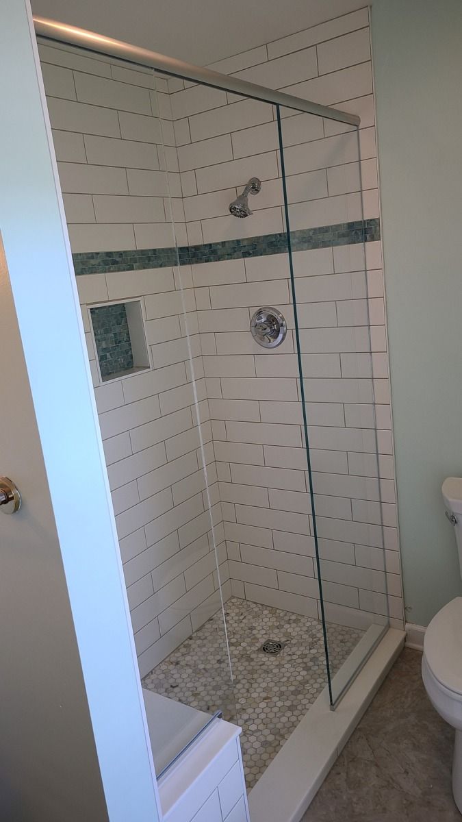 A bathroom with a walk in shower and a toilet.