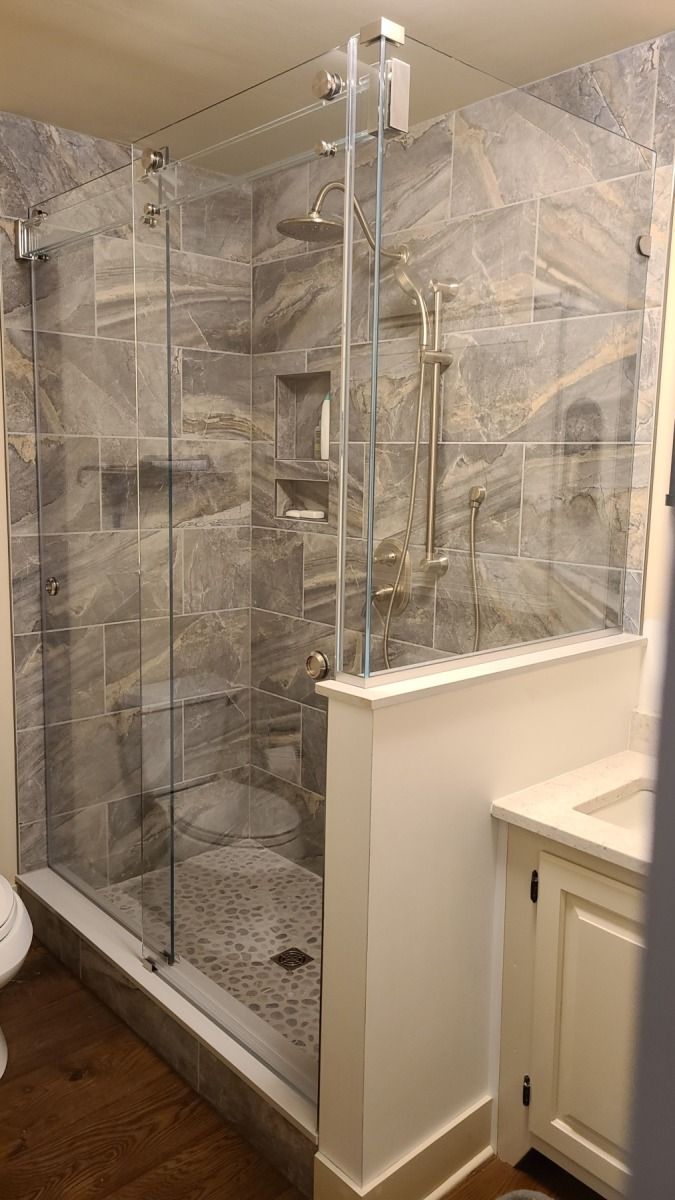 A bathroom with a walk in shower and a sink.