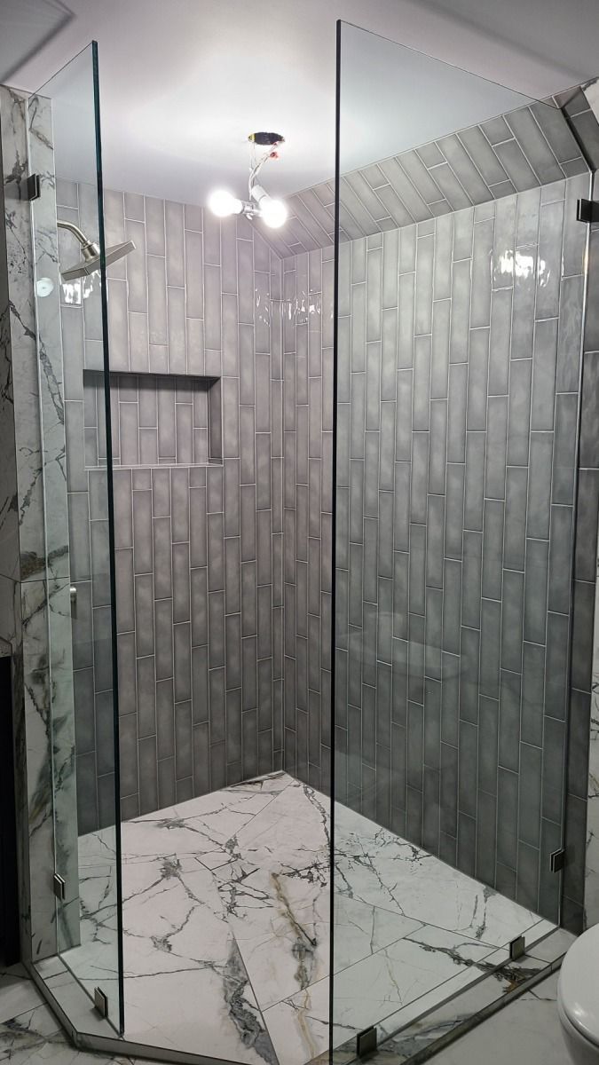 A bathroom with a walk in shower and a toilet.