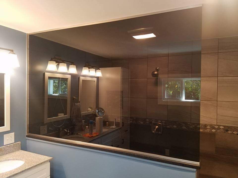 A bathroom with a glass shower door and a sink.