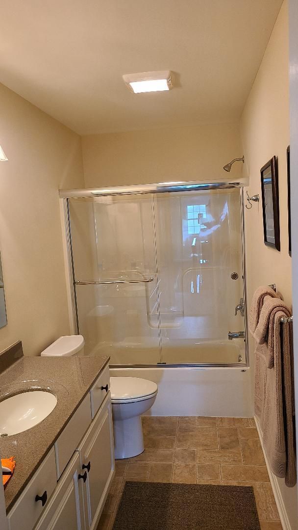 A bathroom with a toilet , sink , tub and shower.
