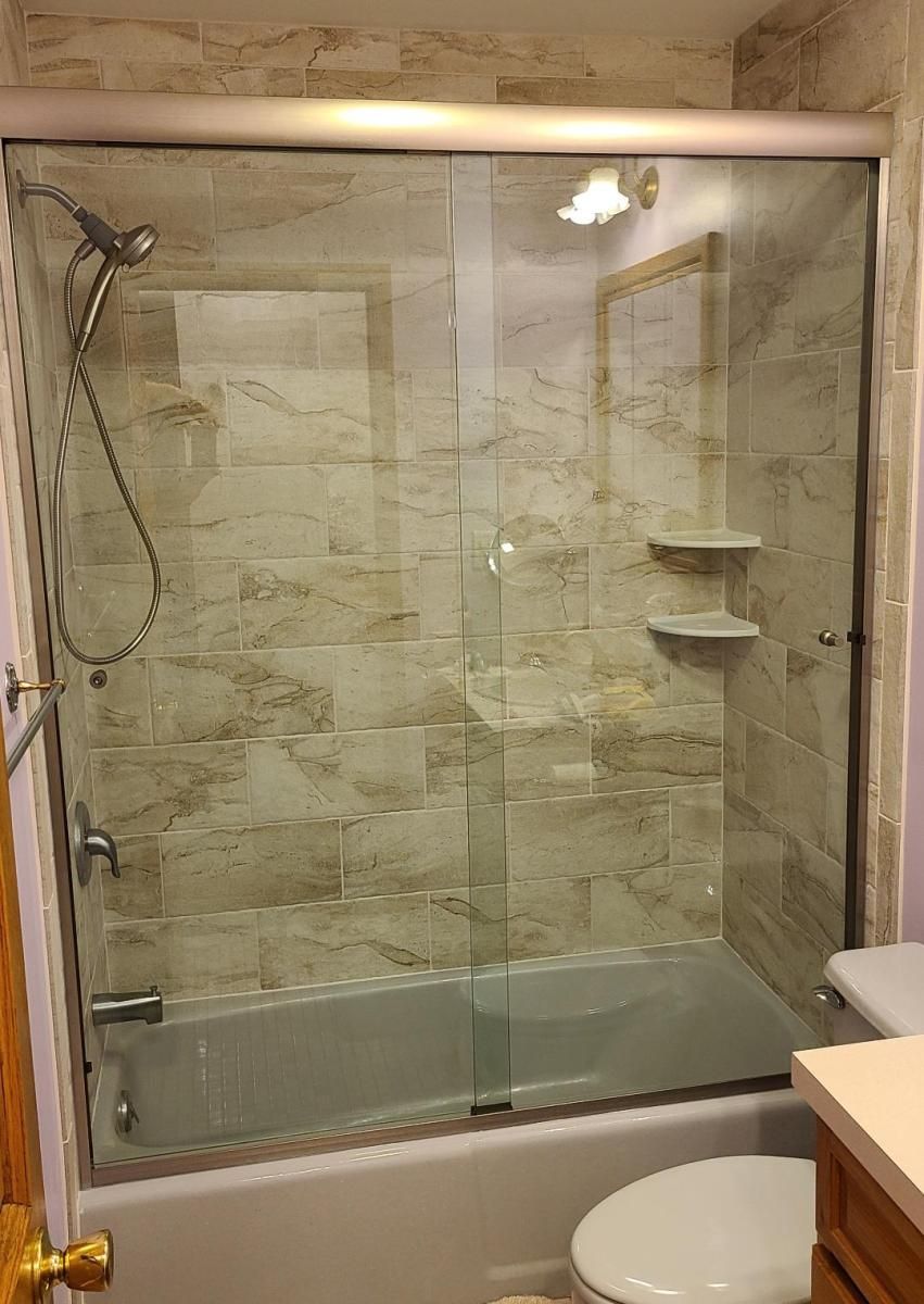 A bathroom with a bathtub , toilet , and shower.