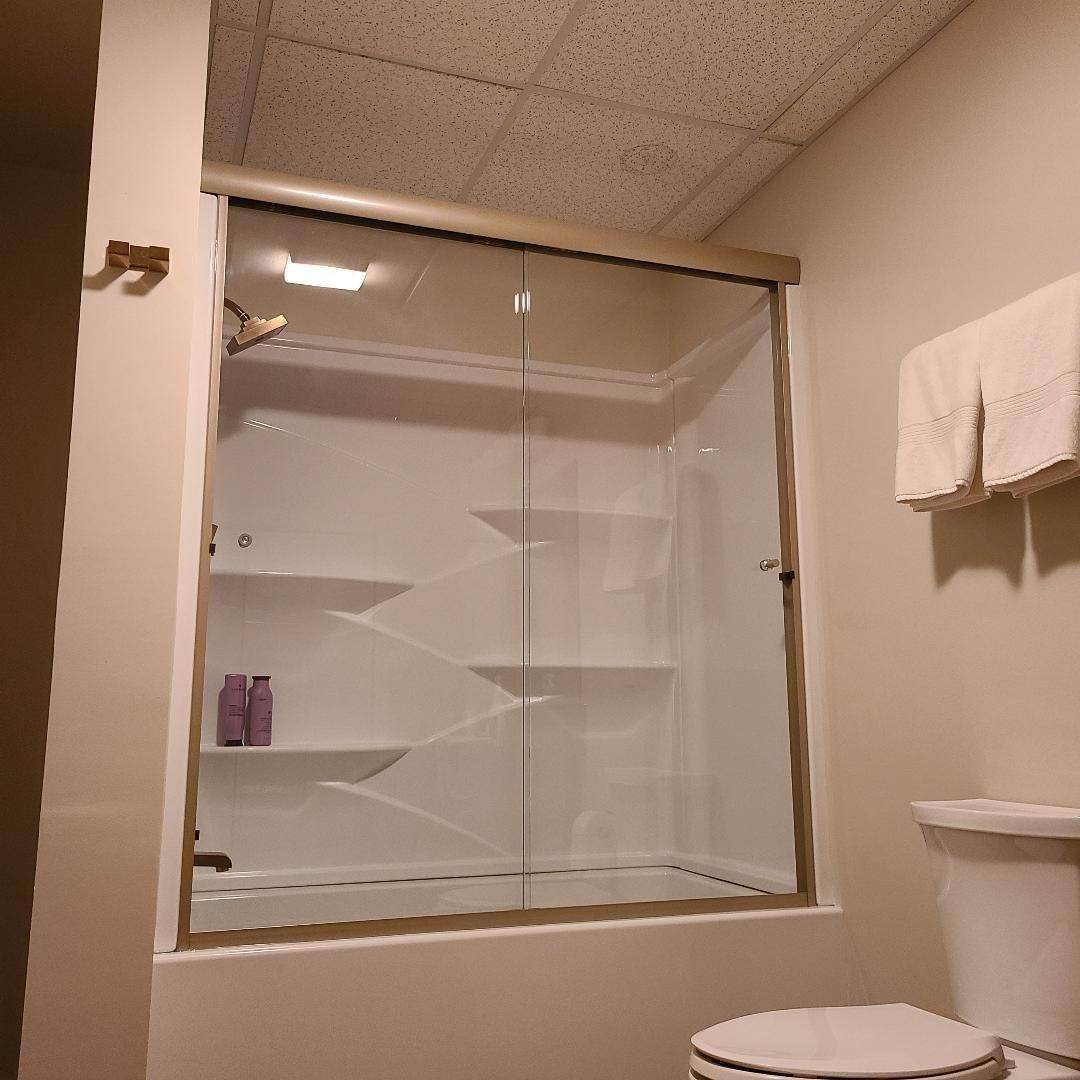 A bathroom with a toilet and a glass shower door