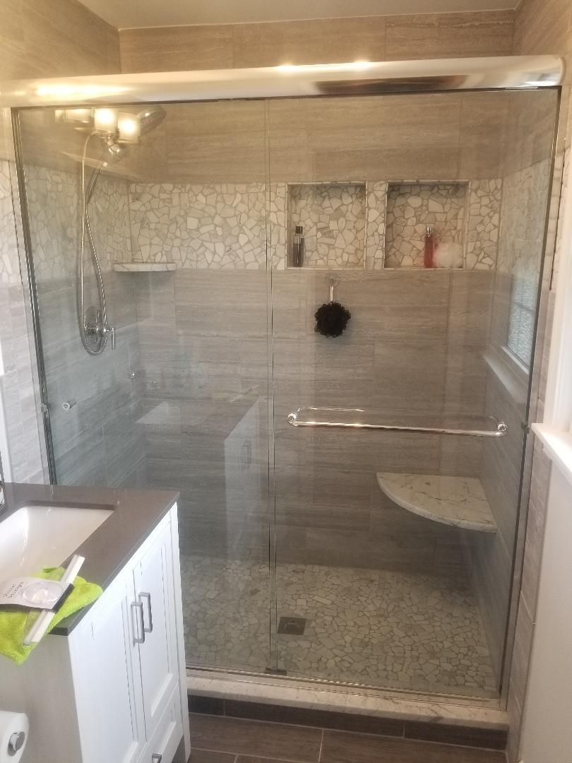 A bathroom with a sliding glass shower door and a sink.
