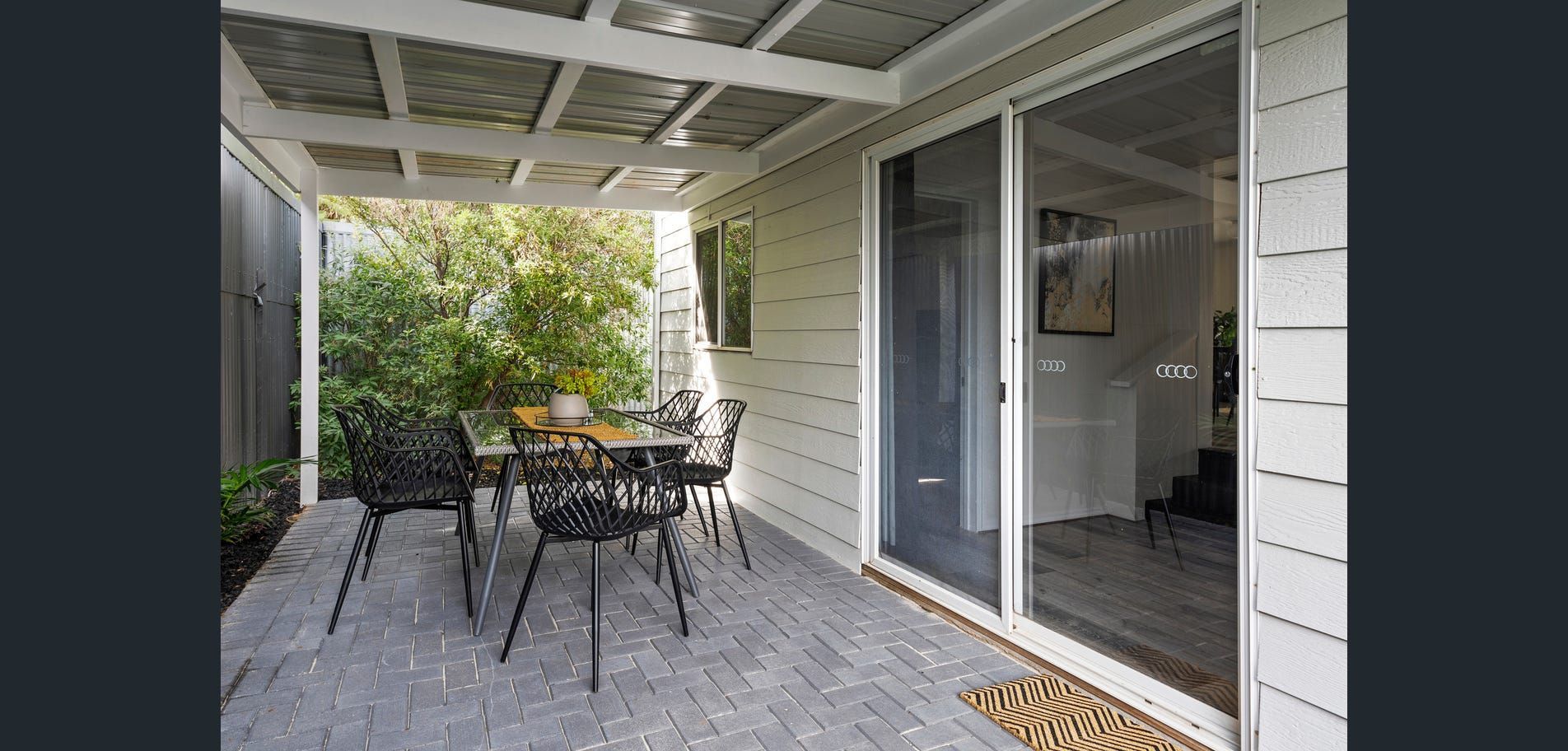 Covered patio with outdoor table and chairs beside sliding glass door