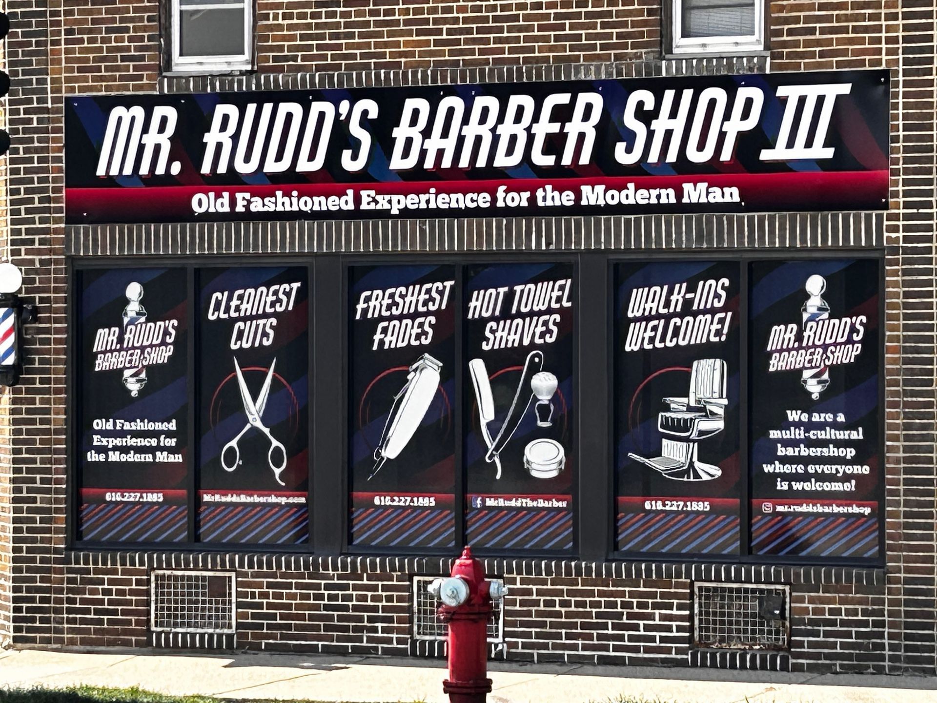 A brick building with a sign that says mr rudd 's barber shop iii