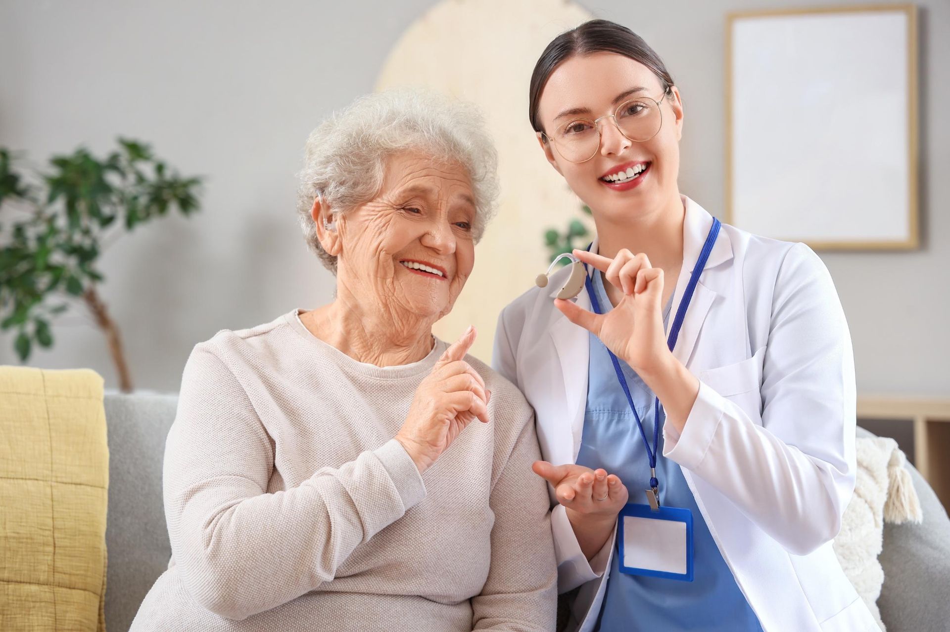 Nurse smiling beside a patient, holding a medication vial in a bright care room