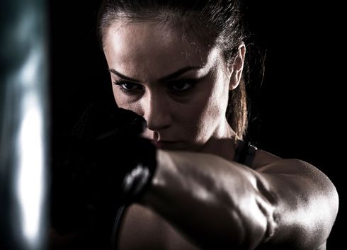 girl in krav maga class practicing a jab cross drill on the heavy bag
