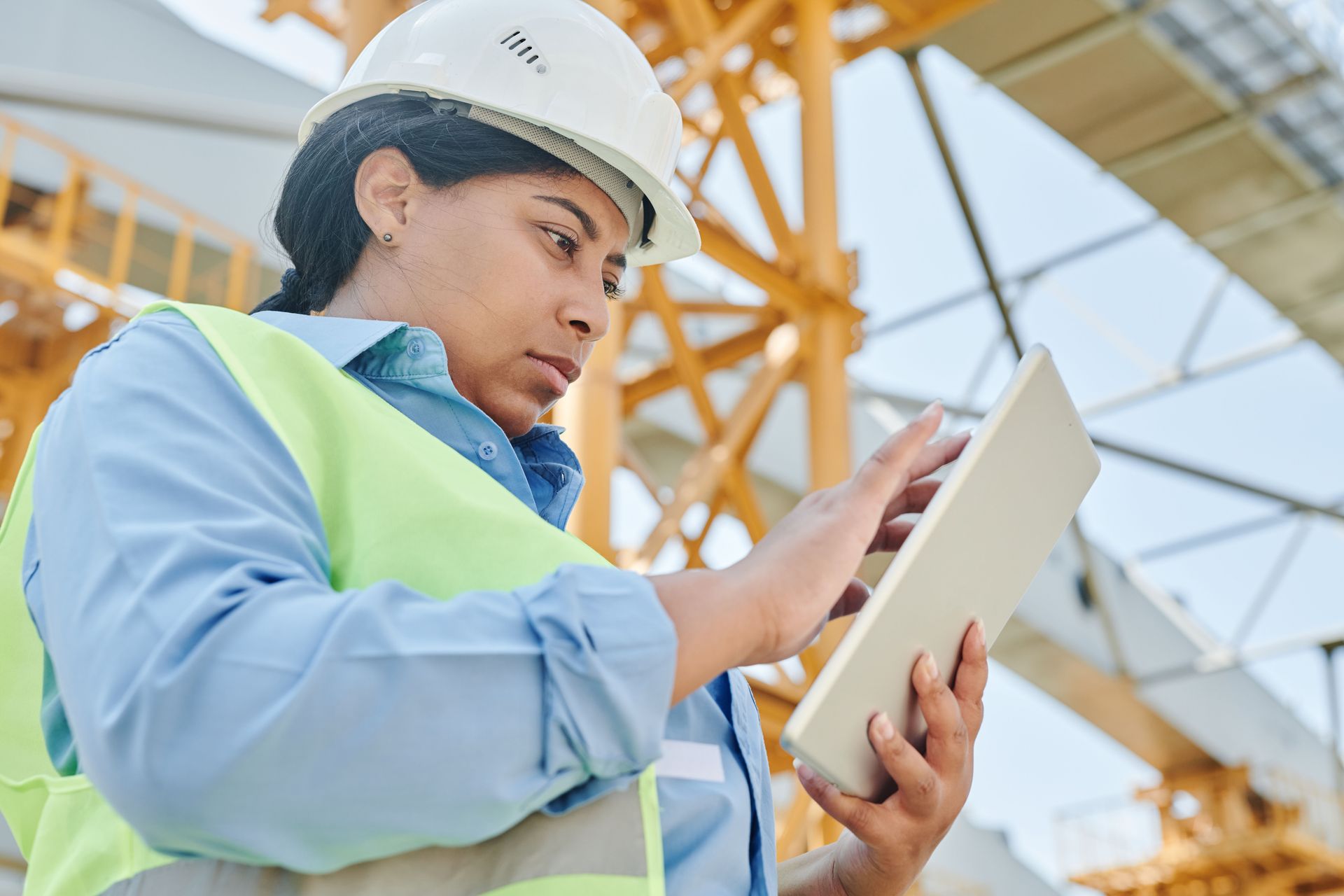 Construction manager on a job site using a tablet, content strategy for construction companies