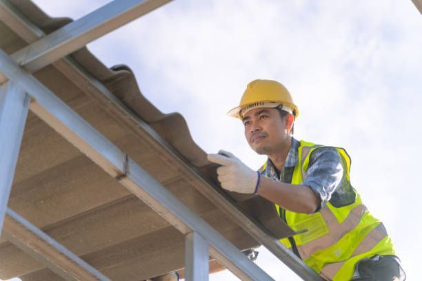 A construction worker is installing roof tiles at a construction site.
