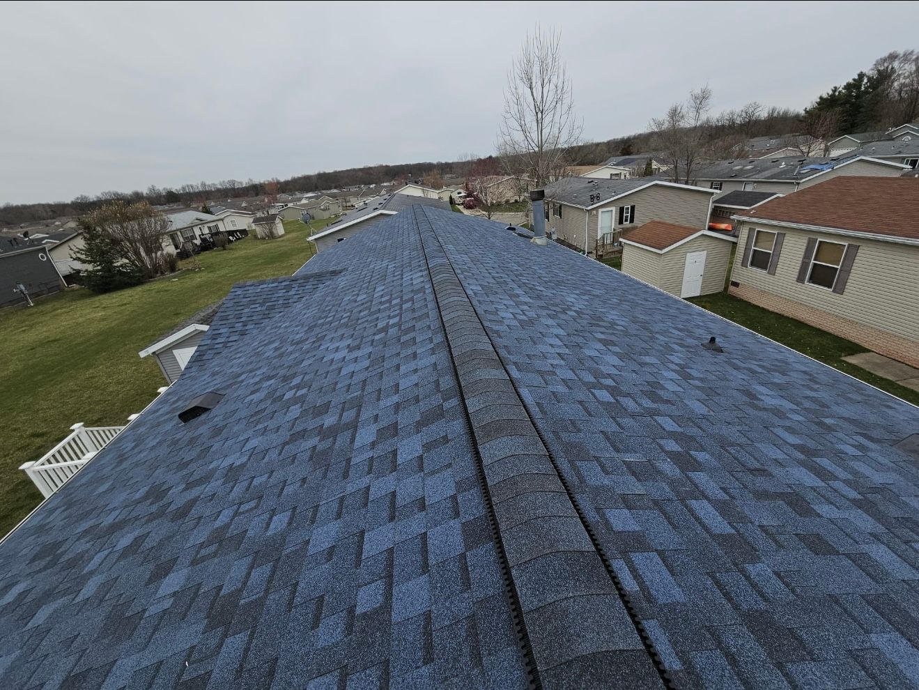 A blue roof of a house with a lot of houses in the background.