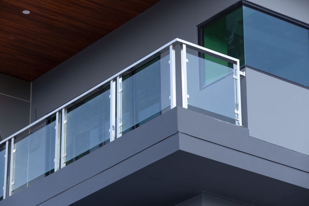 A Balcony With a Glass Railing on the Side of a Building — Fast Glass & Glazing In Tamworth, NSW